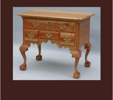 reproduction of a philadelphia chippendale lowboy in curly cherry with ball and claw feet and knee shells